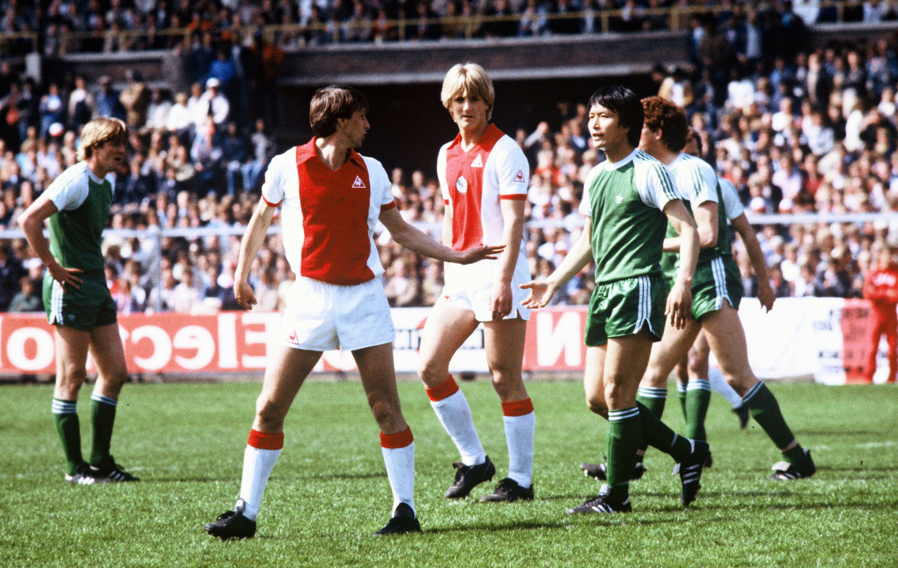 Johan Cruijff discussieert met Jung-moo Huh, op de achtergrond Wim Kieft
