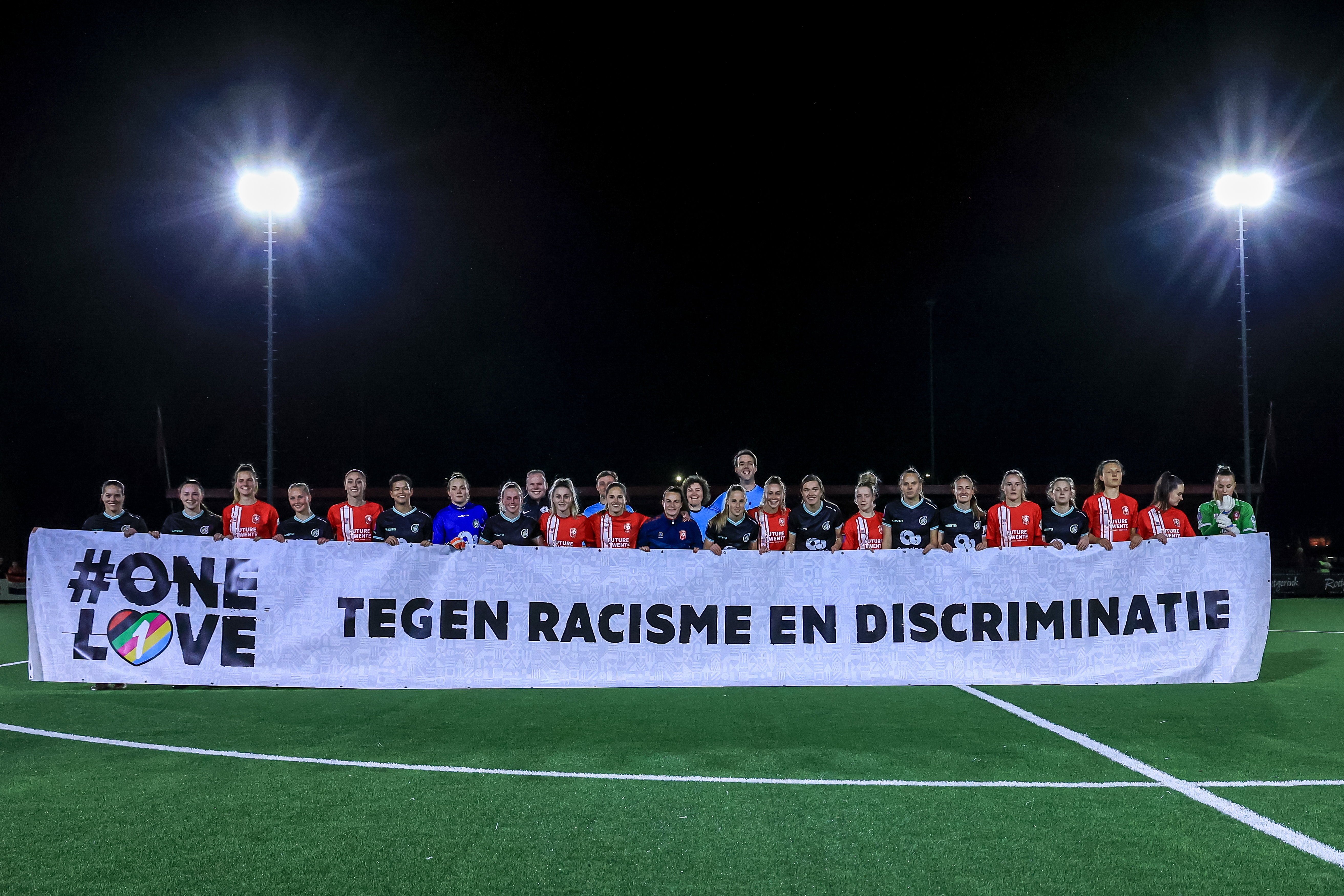 Speelsters van FC Twente en Fortuna Sittard in 2023 met een spandoek tegen racisme en discriminatie