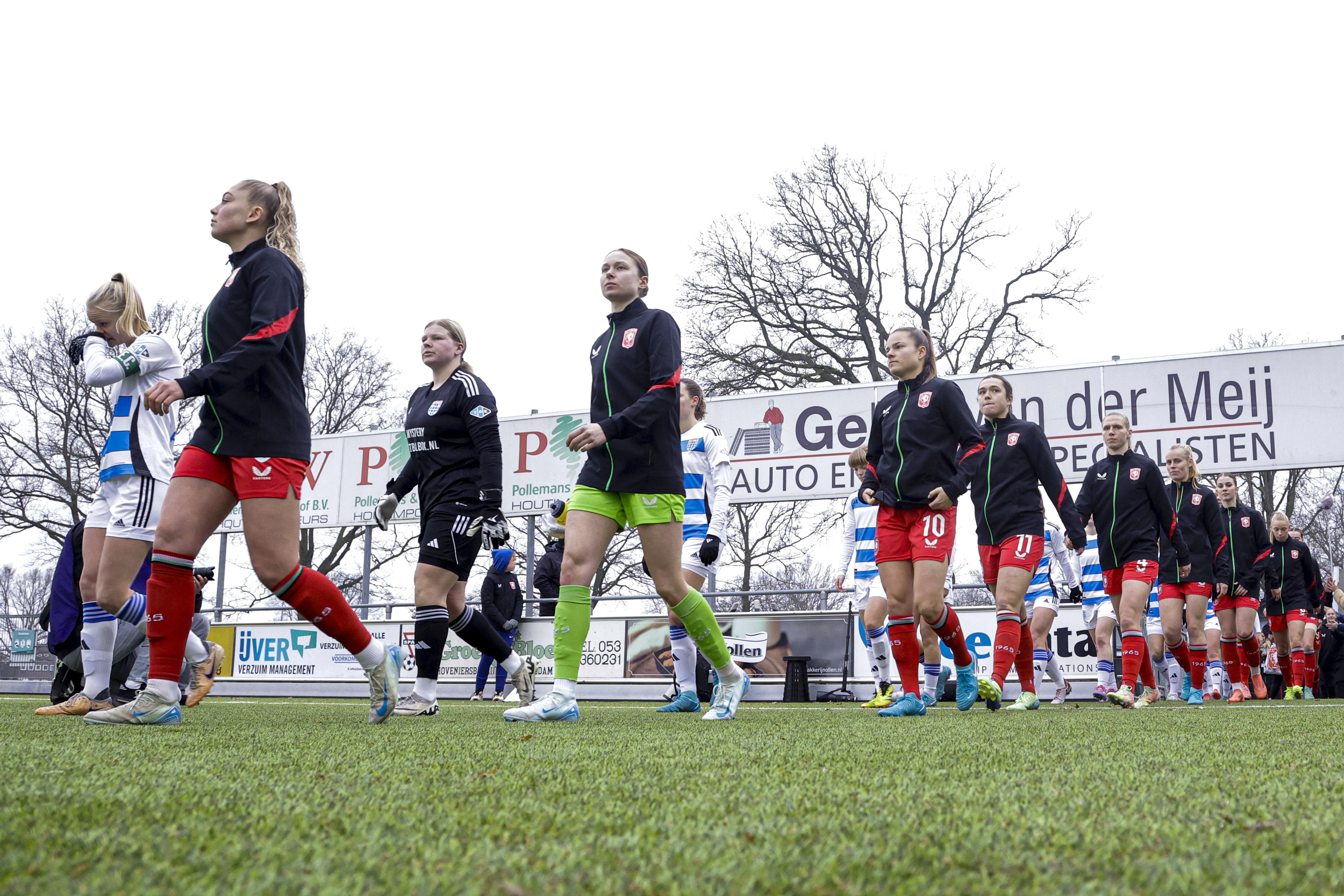 De speelsters van PEC Zwolle en FC Twente lopen het veld op