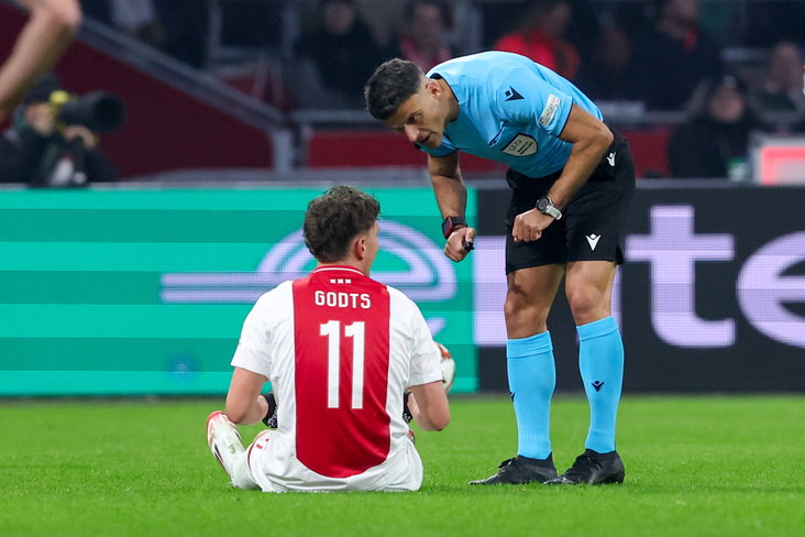 Mika Godts zit geblesseerd op het gras