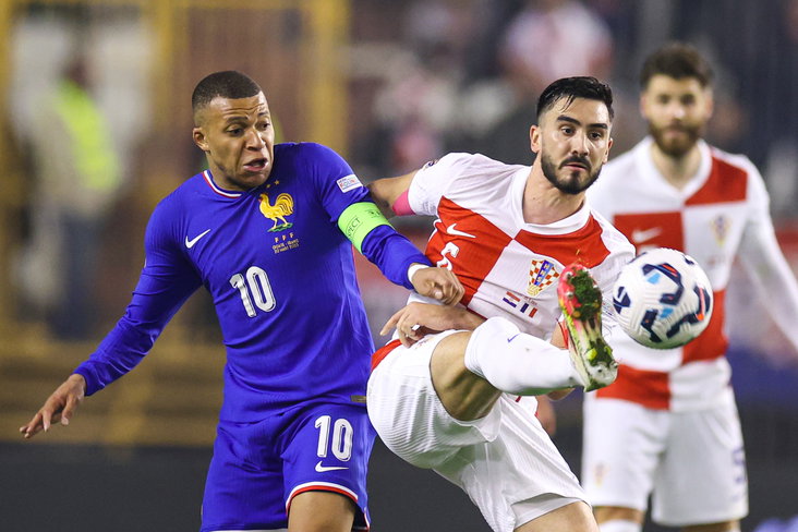 Josip Sutalo in duel met Kylian Mbappé