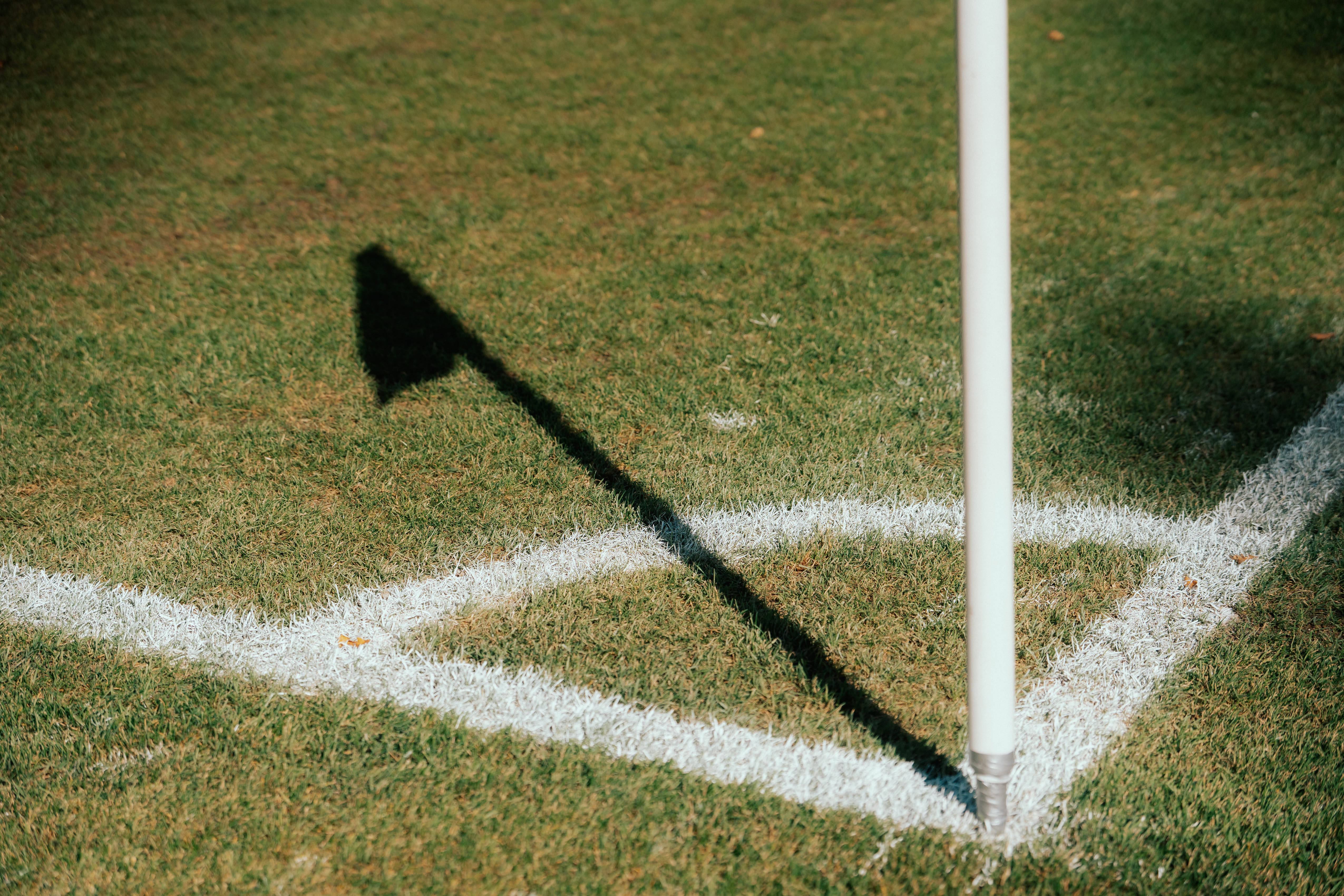 De schaduw van een cornervlag op een voetbalveld