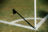 De schaduw van een cornervlag op een voetbalveld