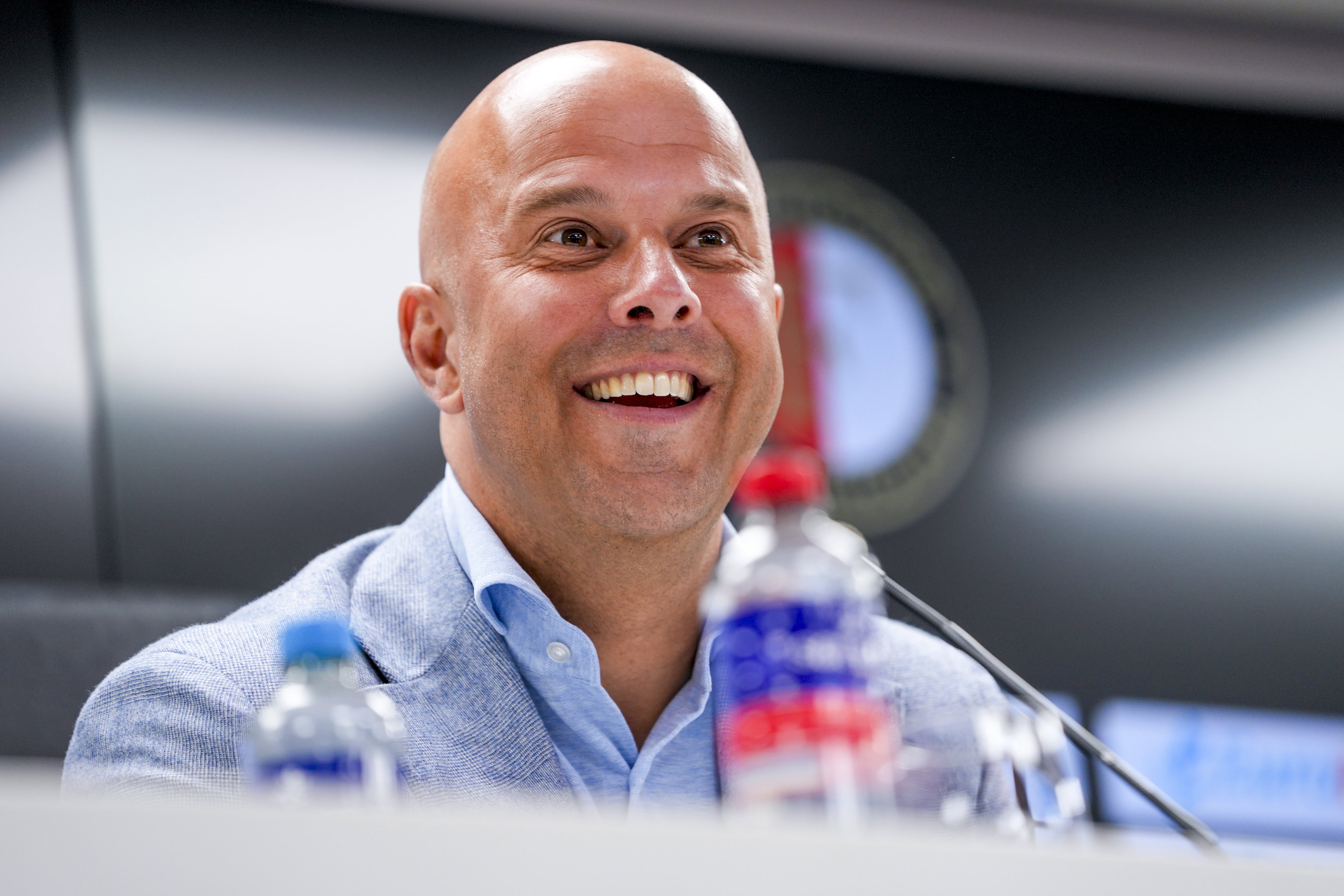 Arne Slot lachend op de persconferentie in De Kuip