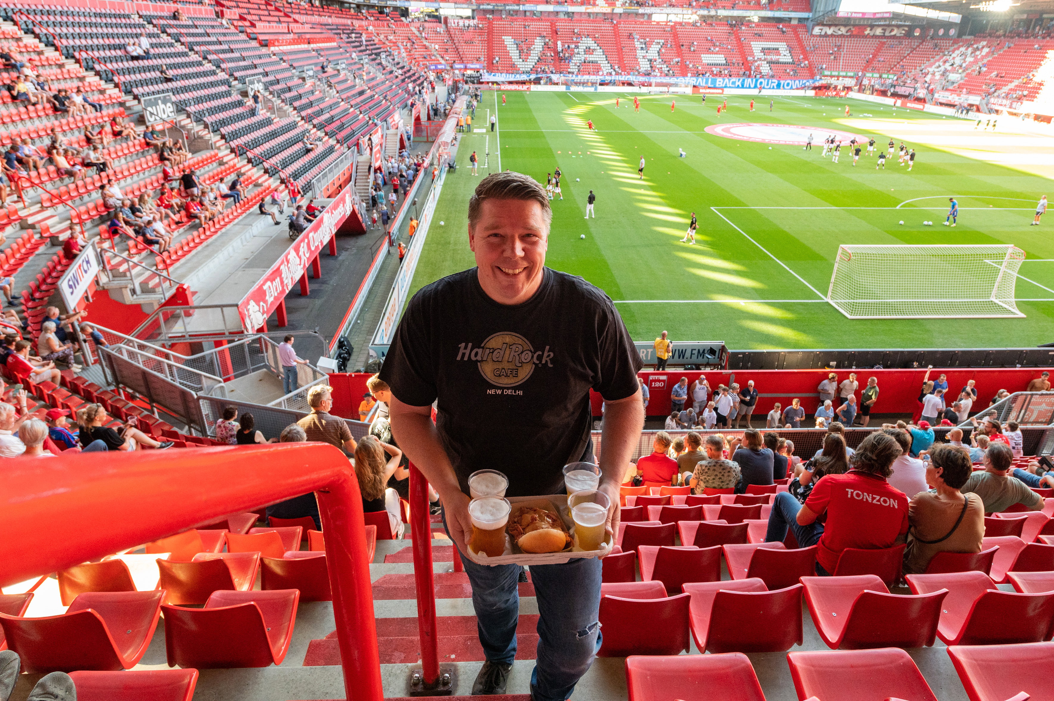 Een supporter met bier en een broodje beenham in De Grolsch Veste