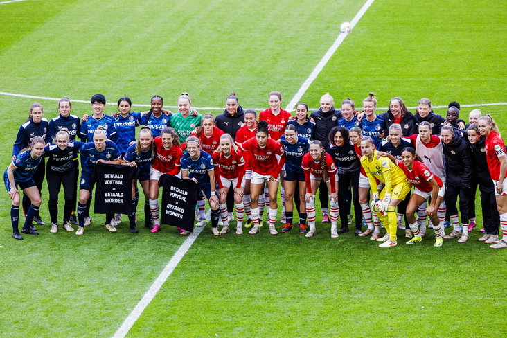 De speelsters van PSV en Feyenoord tonen een shirt met 'betaald voetbal = betaald worden'