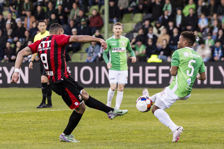 Jeredy Hilterman schiet de bal lek tegen John Hilton