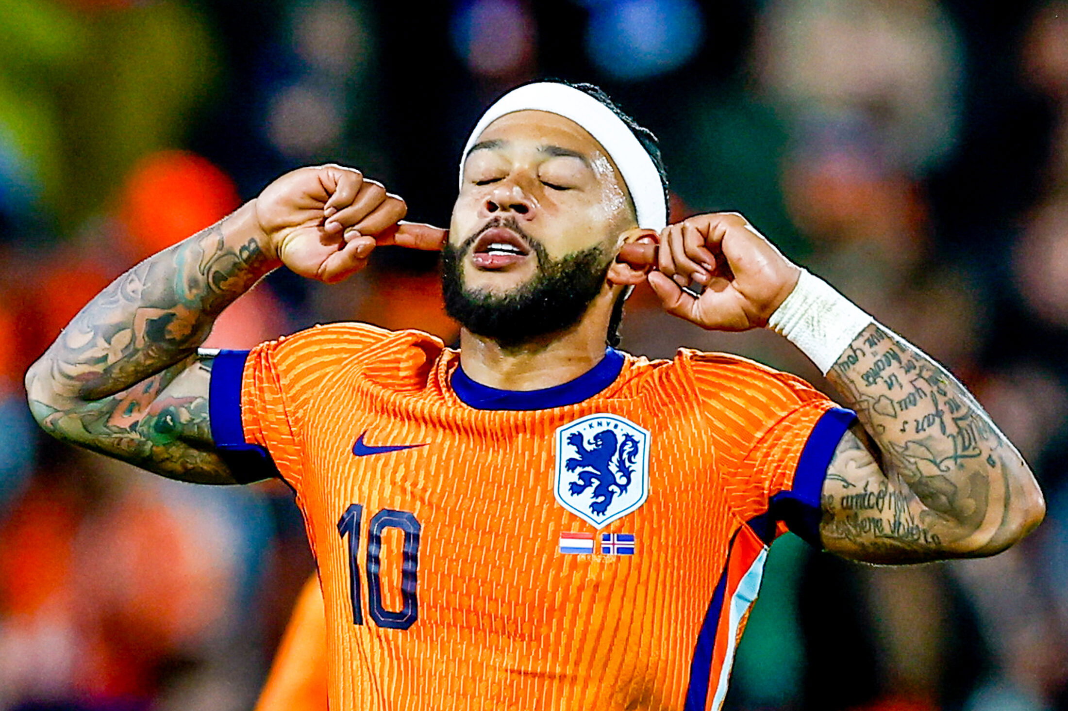Memphis Depay stopt twee vingers in zijn oren
