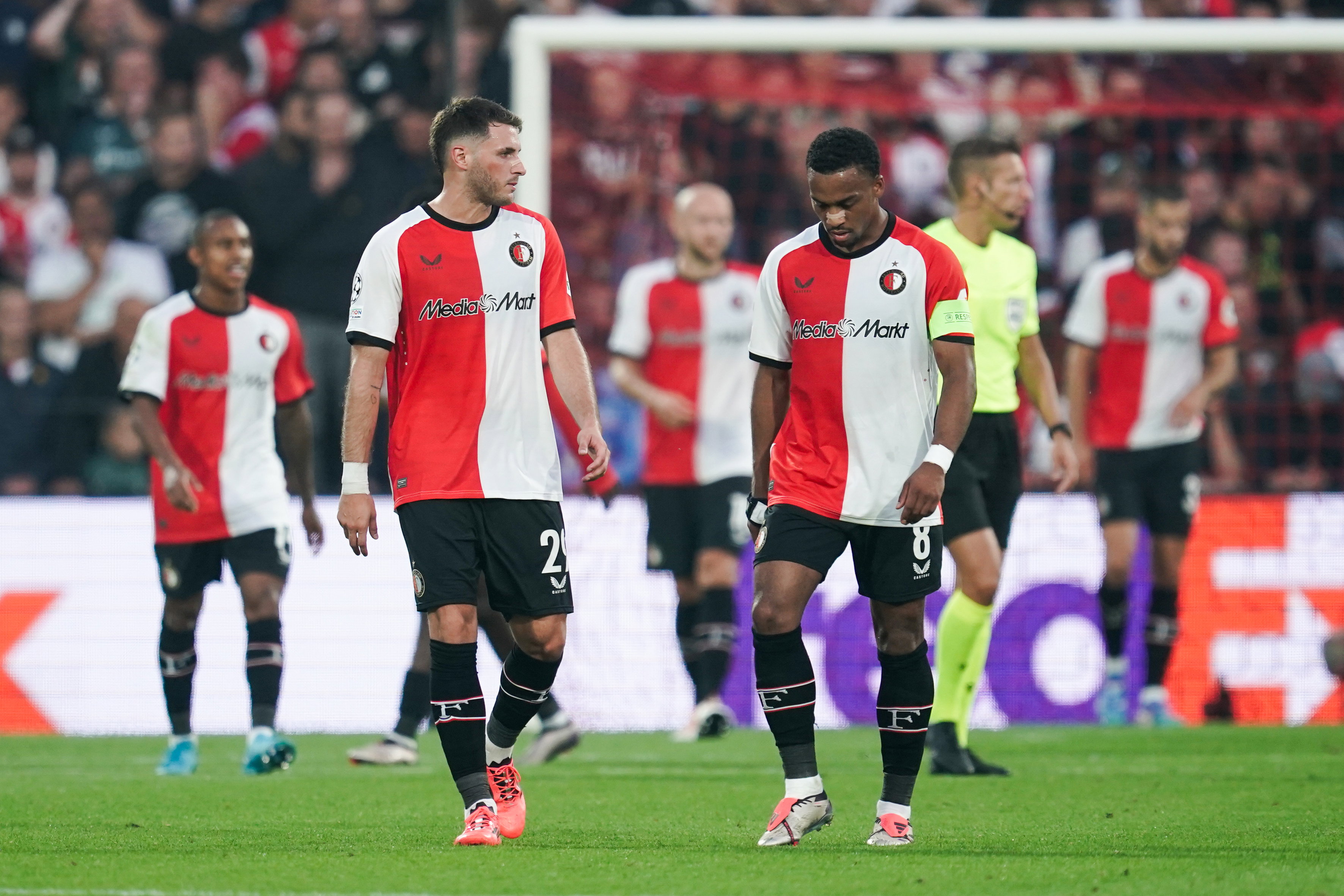 Santiago Gimenez en Quinten Timber lopen bedroefd weg na weer een tegengoal tegen Leverkusen