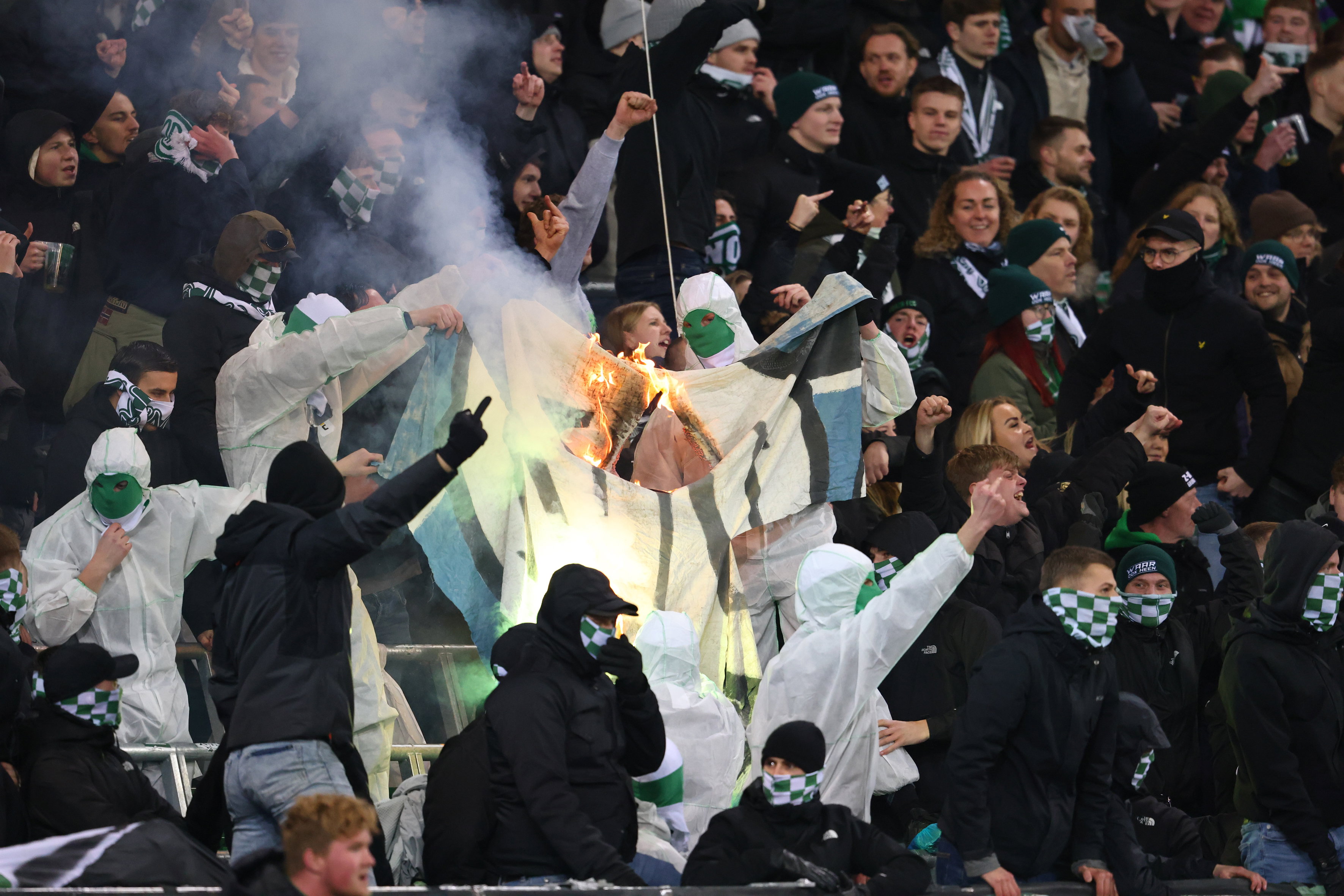 FC Groningen-fans steken een doek van SC Heerenveen-fans in brand