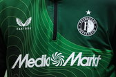 De logo's van Feyenoord, Castore en MediaMarkt op een jack van Feyenoord