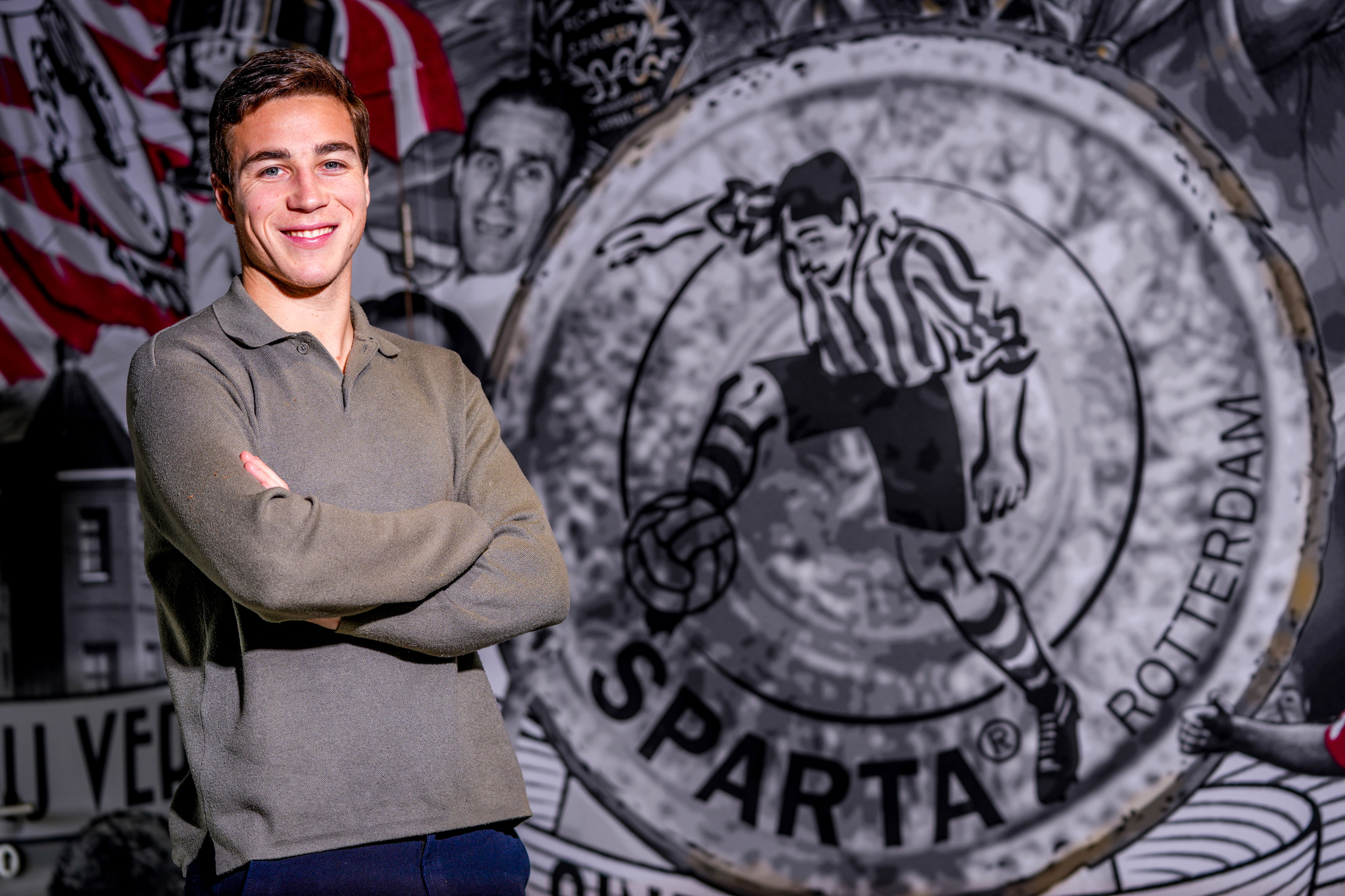 Carel Eiting bij het logo van Sparta Rotterdam