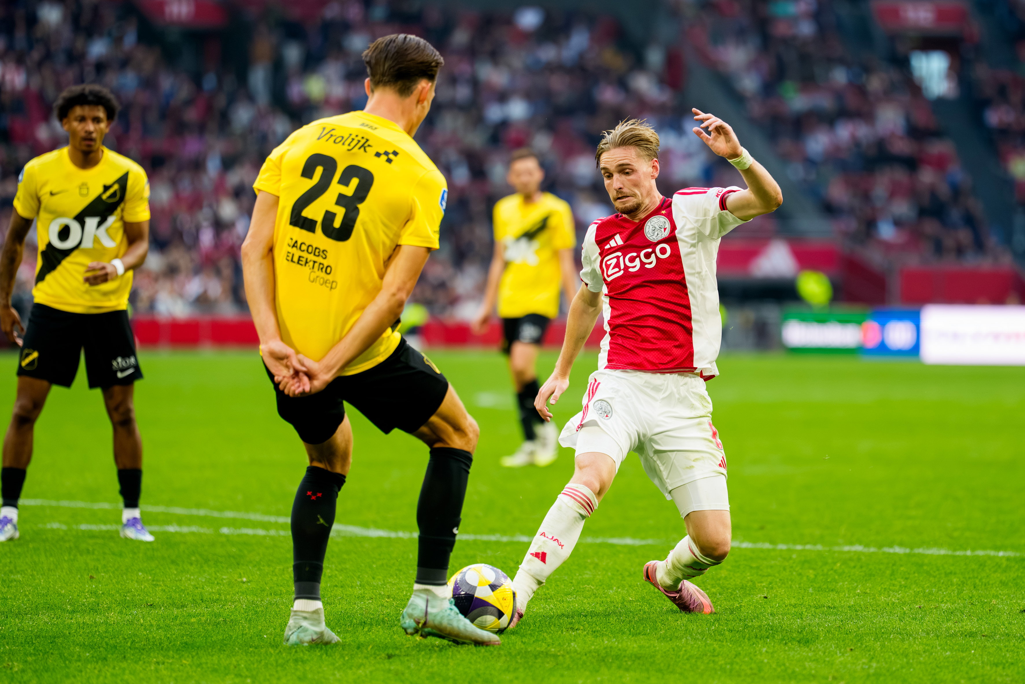 Een duel tussen Dion Versluis (NAC Breda) en Kenneth Taylor (Ajax)