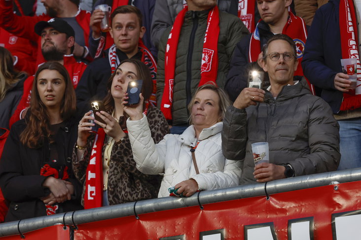 FC Twente fans houden hun telefoons in de lucht tijdens het eerbetoon