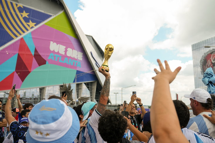 Een supporter houdt een wereldbeker omhoog