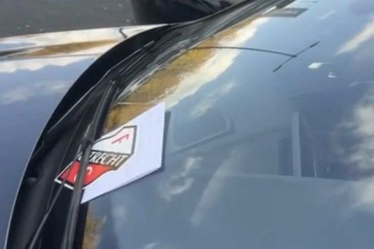 De sticker en het briefje onder de ruitenwisser