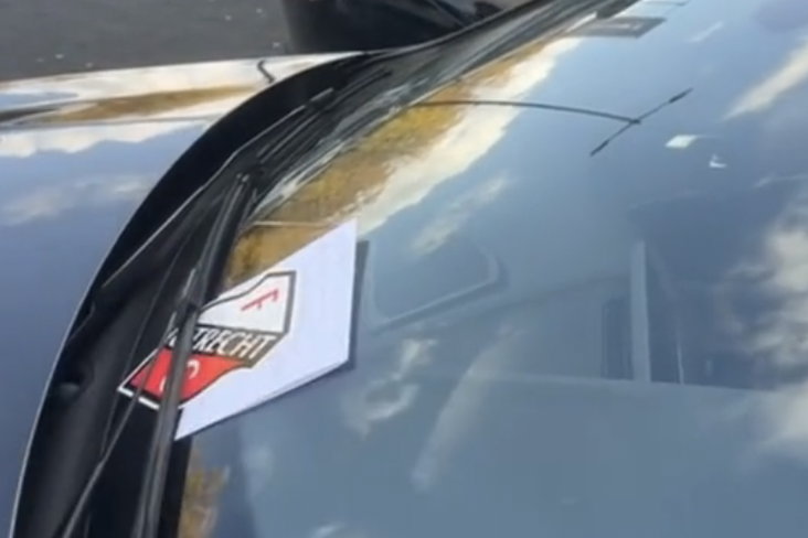 De sticker en het briefje onder de ruitenwisser