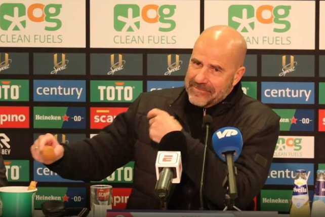 Peter Bosz neemt een bitterbal na de overwinning op FC Groningen