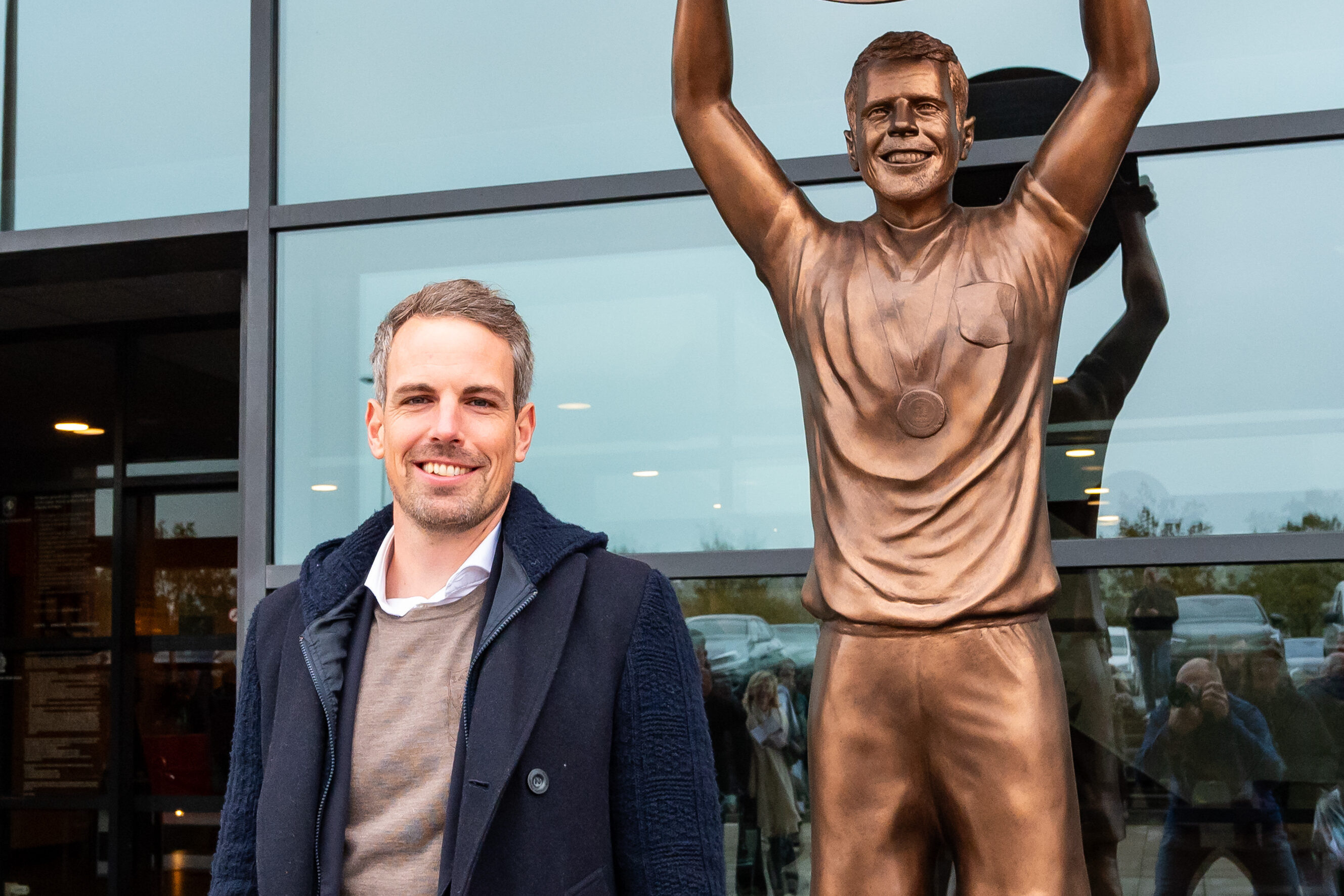 Wout Brama poseert bij standbeeld
