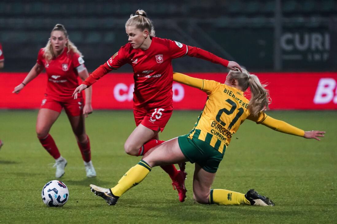 June Burgers (ADO Den Haag) zet een tackle in op Jill Diekman (FC Twente)