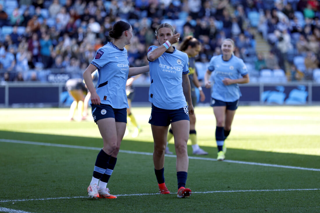 Kerstin Casparij kust haar polsband met een transgendervlag