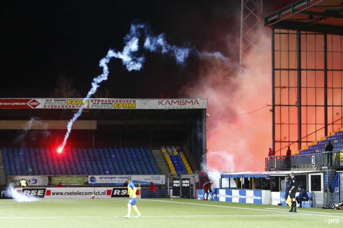 Supporters van SC Cambuur gooien vuurwerk op het veld