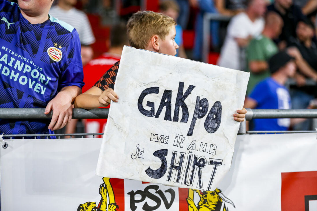 Een PSV-supporter met een bedelbordje