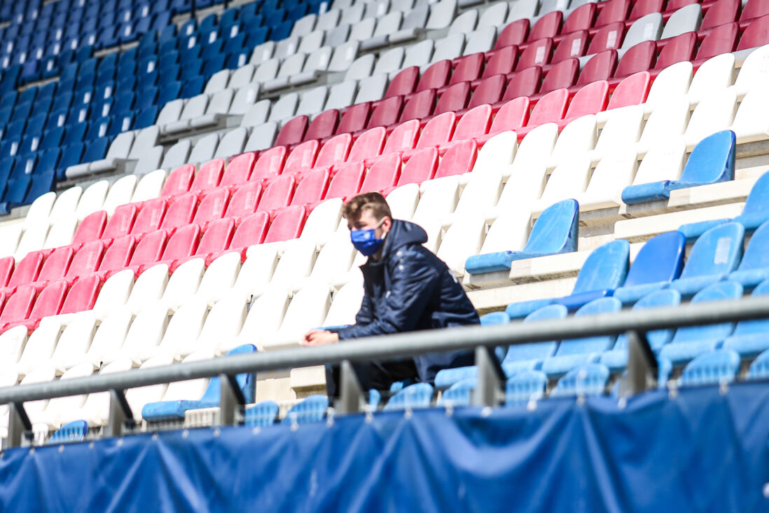 Een ballenjongen met een mondkapje in een leeg Abe Lenstra Stadion