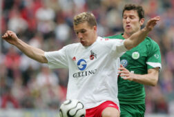 Peter Van der Heyden als speler van VfL Wolfsburg in duel met Lukas Podolski