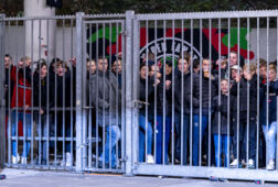 De fans van NEC bekijken een thuiswedstrijd achter een hek