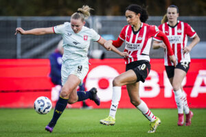 Een duel tussen Jaimy Ravensbergen (FC Twente) en Nina Nijstad (PSV)