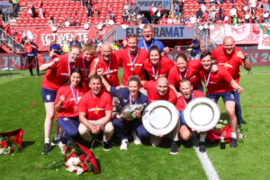 De staf van FC Twente, inclusief hoofdtrainer Joran Pot, met de drie prijzen