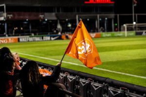 Een vlag met het logo van de OranjeLeeuwinnen