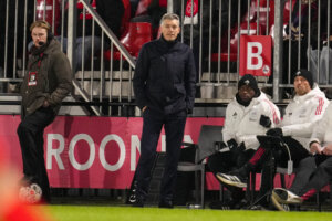 Willem Weijs langs de lijn bij Jong Ajax, met twee stafleden op de bank