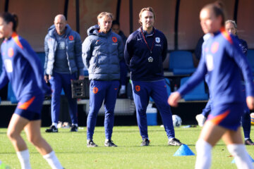 Andries Jonker en Arvid Smit kijken toe bij een training van de OranjeLeeuwinnen