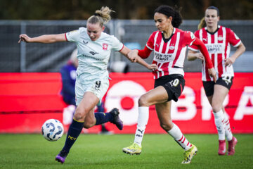 Een duel tussen Jaimy Ravensbergen (FC Twente) en Nina Nijstad (PSV)