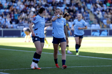 Kerstin Casparij kust haar polsband met een transgendervlag