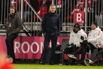 Willem Weijs langs de lijn bij Jong Ajax, met twee stafleden op de bank