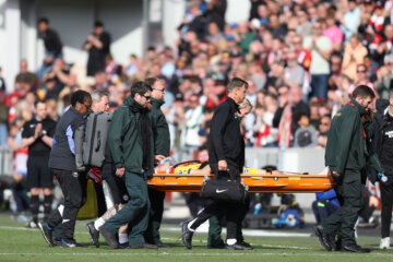 Jan Paul van Hecke per brancard van het veld gedragen