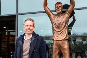 Wout Brama poseert bij standbeeld