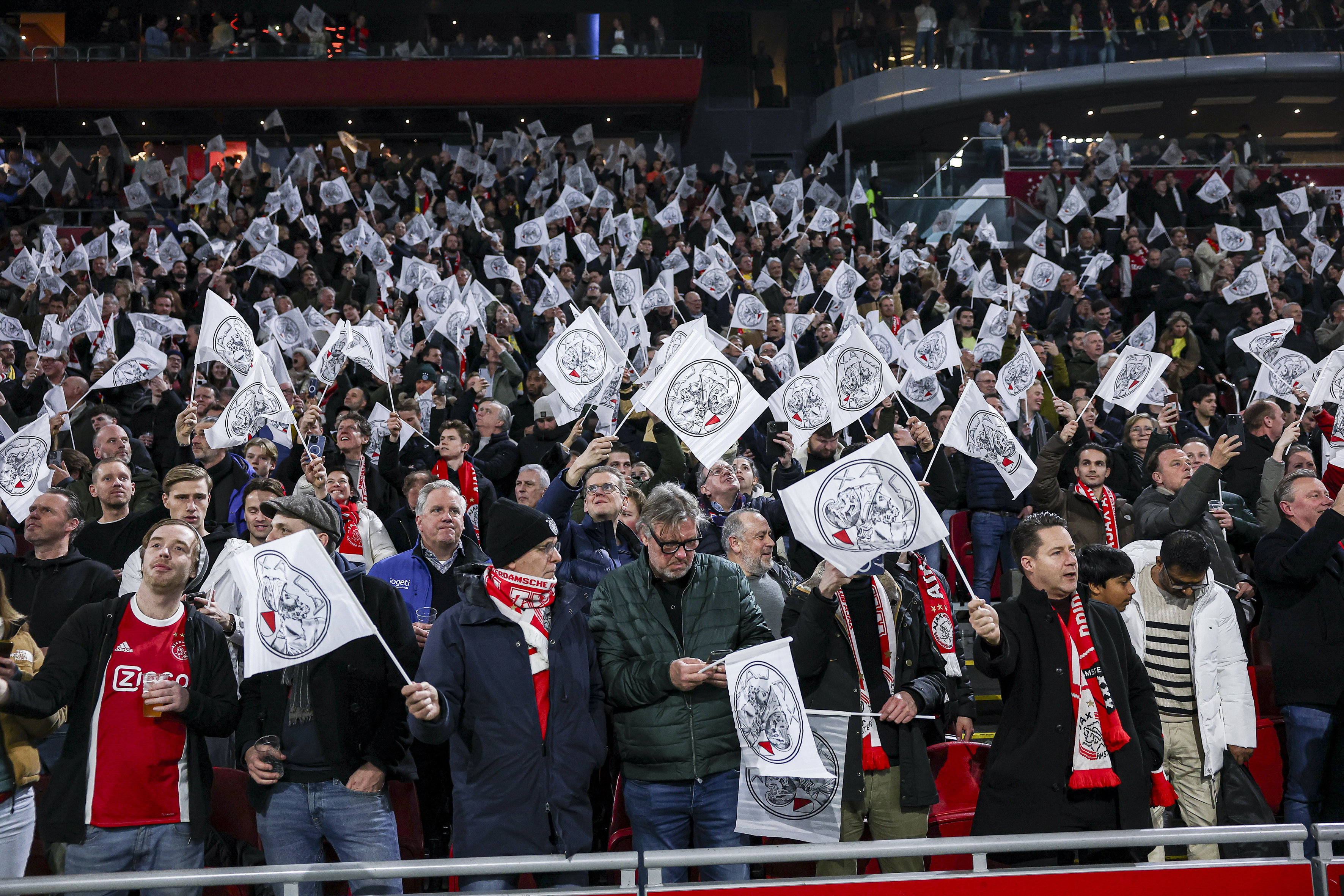 Ajax-fans zwaaien met vlaggetjes in de Arena