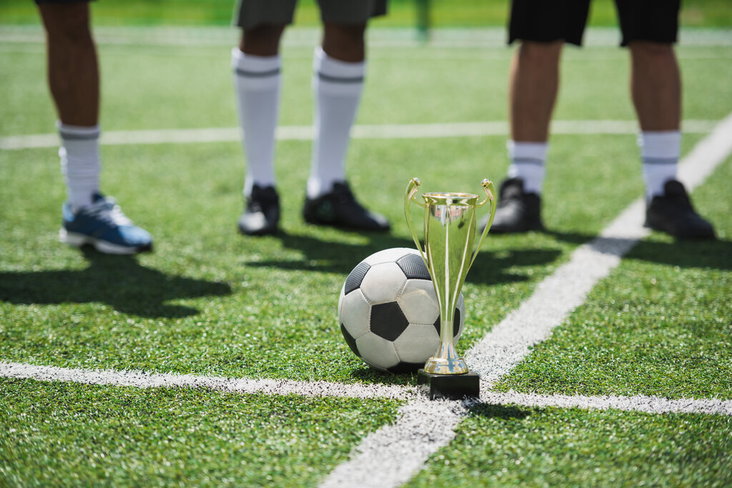 Een beker en een bal op het voetbalveld