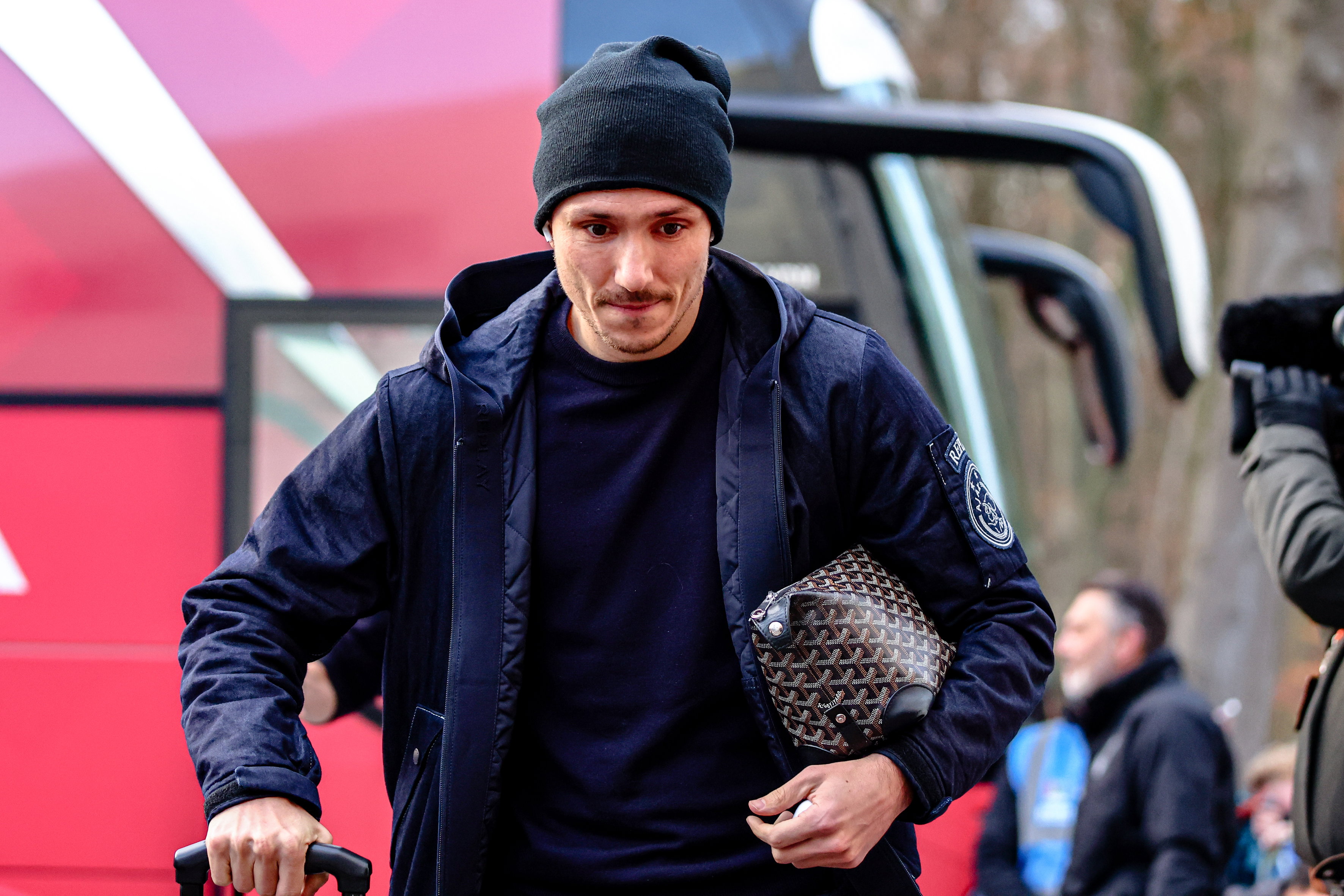 Steven Berghuis loopt weg bij de spelersbus van Ajax