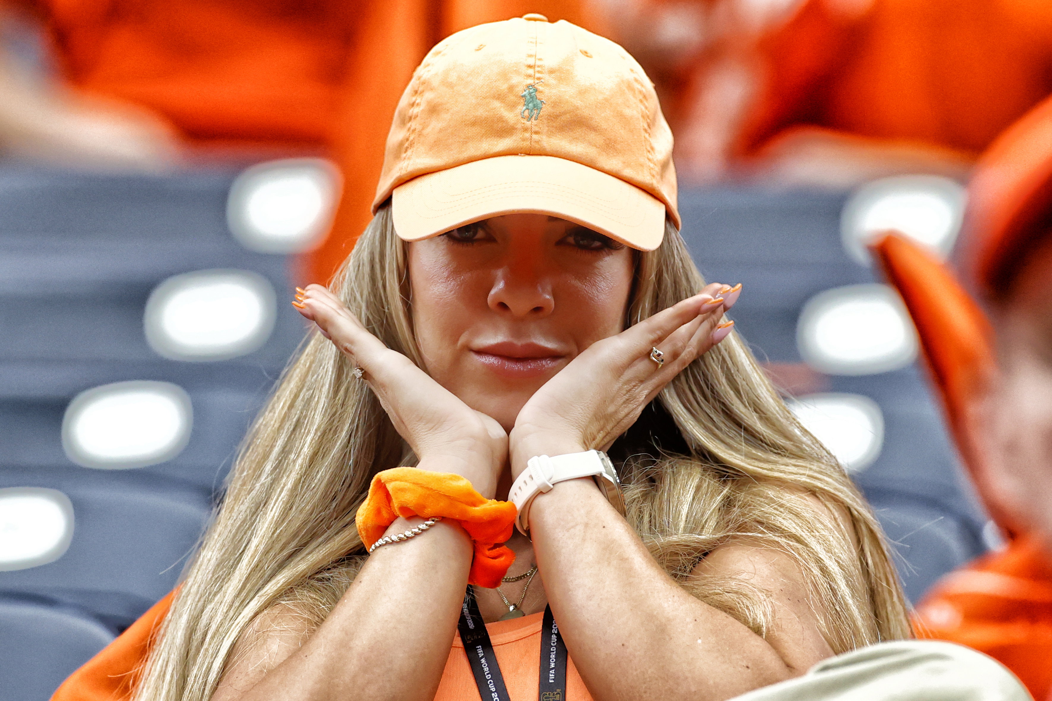 Een vrouw met een oranje pet op de tribune bij het Nederlands elftal