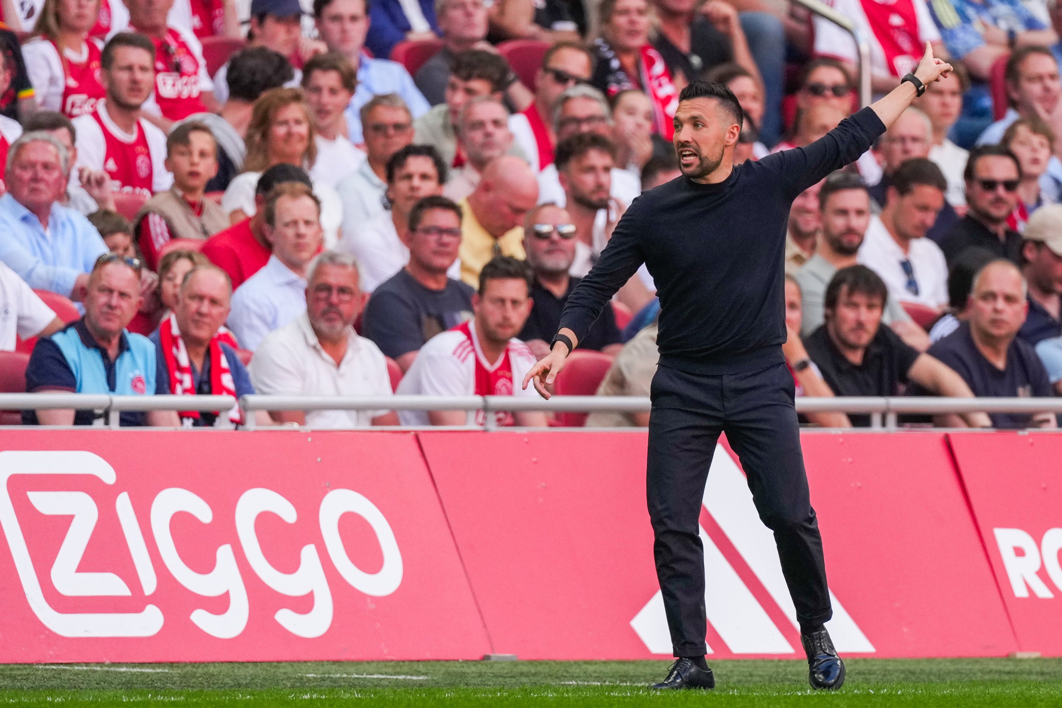 Farioli geeft aanwijzingen in de Arena, ondertussen kijken de Ajax-fans toe