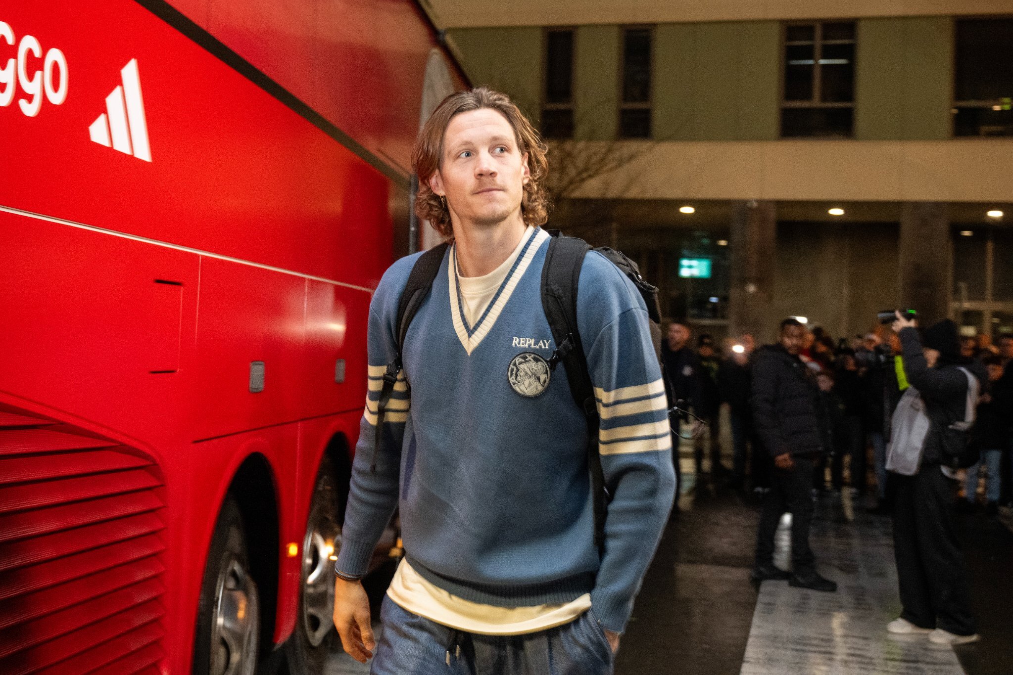 Wout Weghorst loopt naast de spelersbus van Ajax