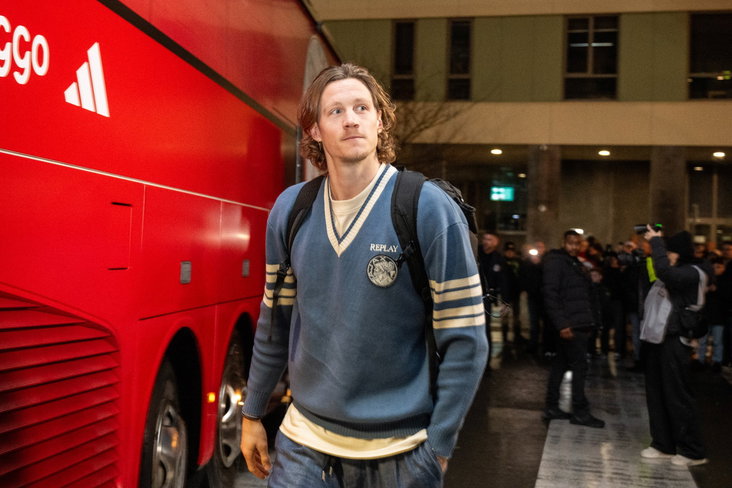 Wout Weghorst loopt naast de spelersbus van Ajax